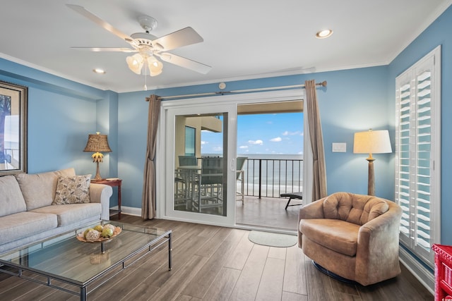 living room featuring ceiling fan, ornamental molding, and wood-type flooring