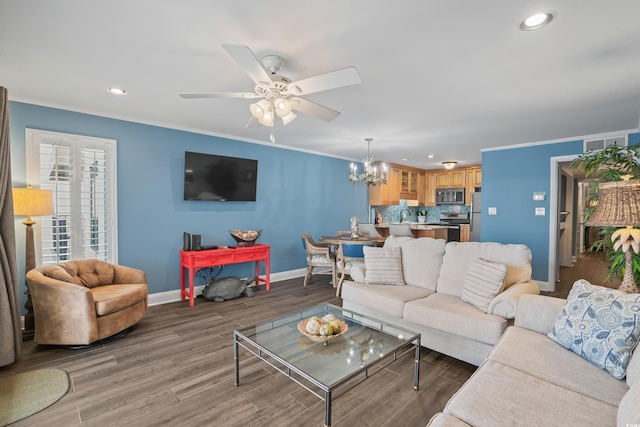 living room with ceiling fan with notable chandelier, dark hardwood / wood-style floors, and crown molding