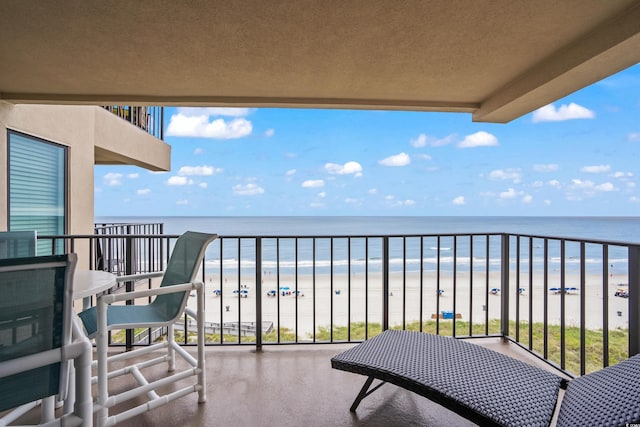 balcony with a water view and a view of the beach