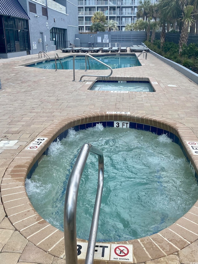 view of swimming pool with a community hot tub