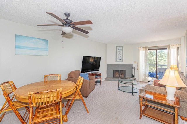 carpeted dining room with a textured ceiling and ceiling fan