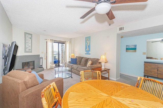 dining room featuring ceiling fan, a textured ceiling, and light hardwood / wood-style floors