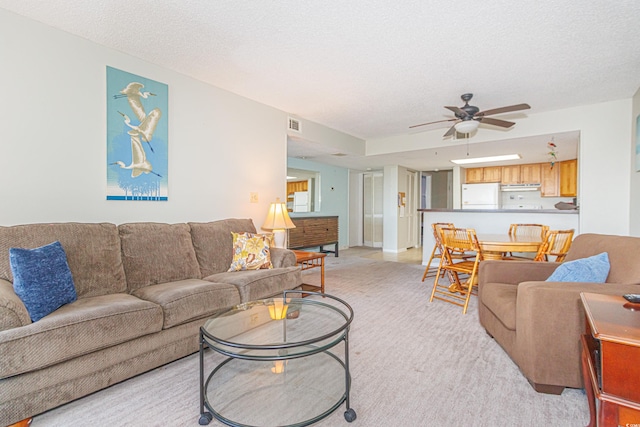 living room with light carpet, a textured ceiling, and ceiling fan