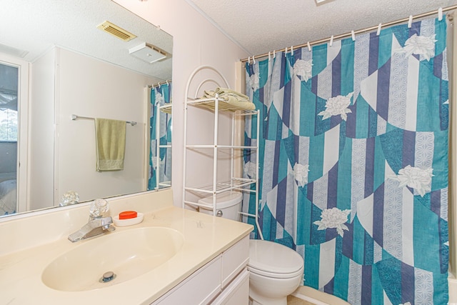 bathroom featuring a textured ceiling, vanity, toilet, and walk in shower