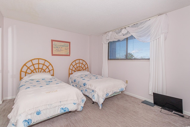 bedroom featuring a textured ceiling and light colored carpet