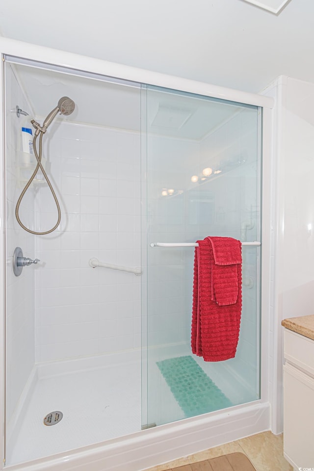 bathroom with walk in shower, vanity, and tile patterned floors