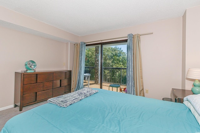 carpeted bedroom with a textured ceiling and access to exterior