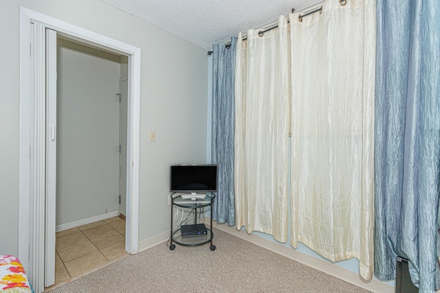 tiled bedroom featuring a textured ceiling