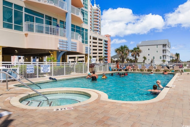 view of pool with a hot tub