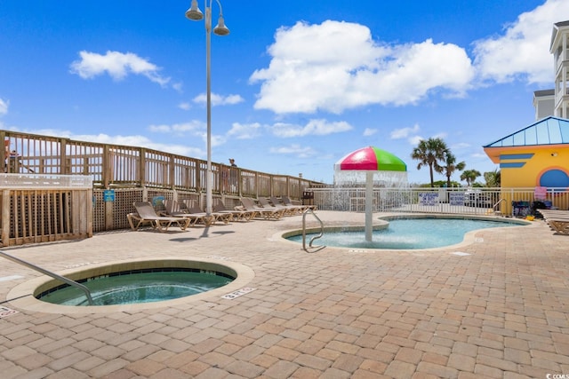 view of swimming pool featuring a community hot tub and a patio area