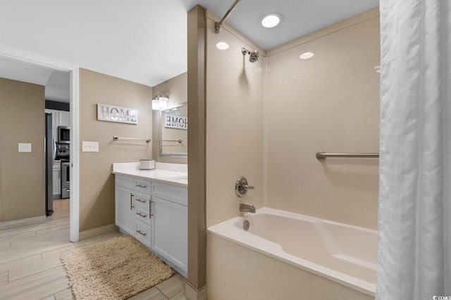 bathroom featuring wood-type flooring, vanity, and shower / bath combo