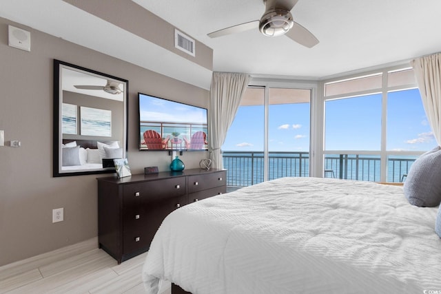 bedroom with multiple windows, light wood-type flooring, ceiling fan, and access to exterior