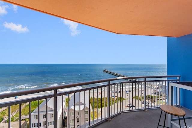 balcony featuring a view of the beach and a water view