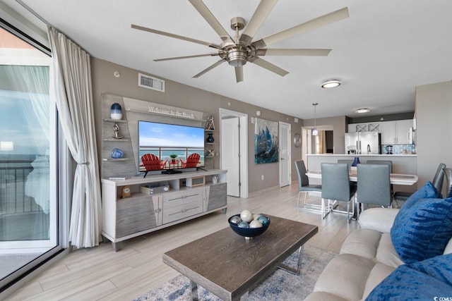 living room featuring light hardwood / wood-style flooring and ceiling fan