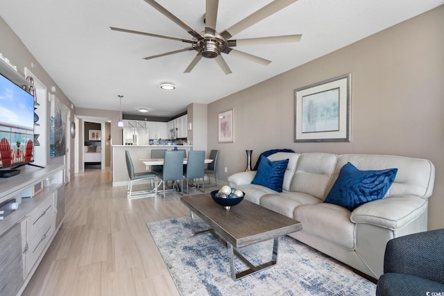 living room featuring ceiling fan and light hardwood / wood-style flooring