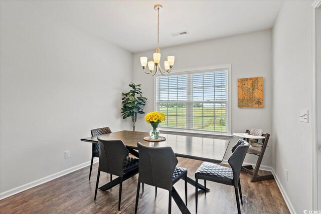 dining area featuring a notable chandelier and dark wood-type flooring