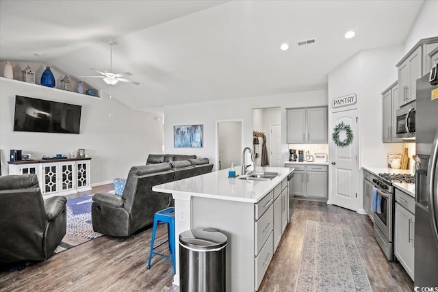 kitchen with open floor plan, stainless steel appliances, gray cabinetry, and visible vents
