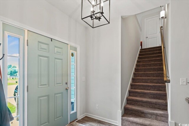 entryway with dark hardwood / wood-style floors and a chandelier