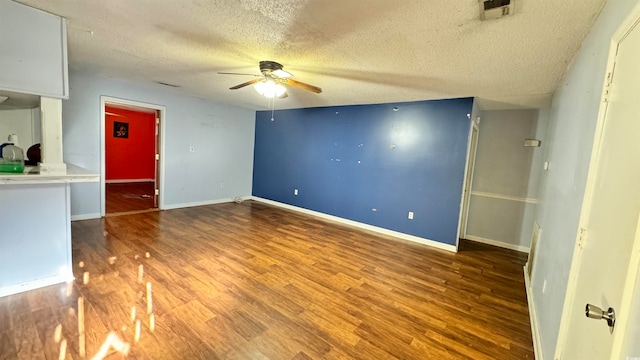 spare room with hardwood / wood-style floors, ceiling fan, and a textured ceiling