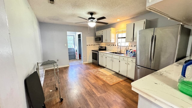 kitchen featuring white cabinetry, sink, hardwood / wood-style floors, a textured ceiling, and appliances with stainless steel finishes