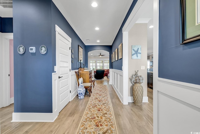 hallway featuring ornamental molding and light hardwood / wood-style flooring