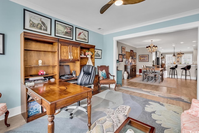 office area featuring light hardwood / wood-style flooring, ceiling fan with notable chandelier, and ornamental molding