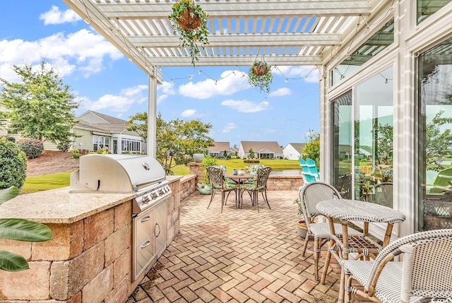 view of patio / terrace featuring a grill, a pergola, and exterior kitchen