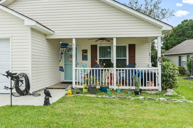 property entrance featuring a lawn, ceiling fan, and a porch