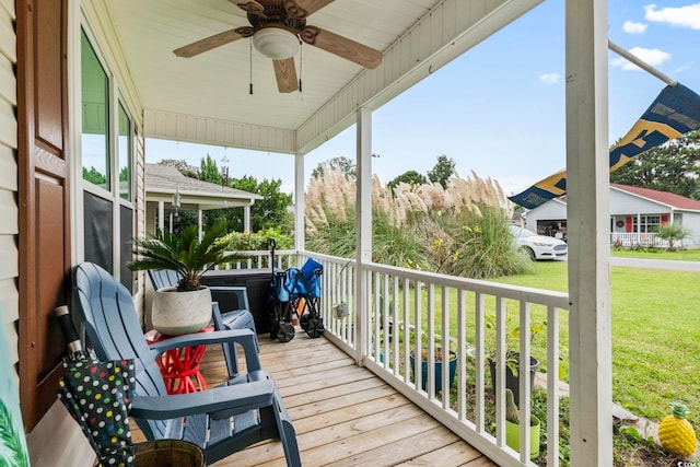 wooden deck with a lawn and ceiling fan