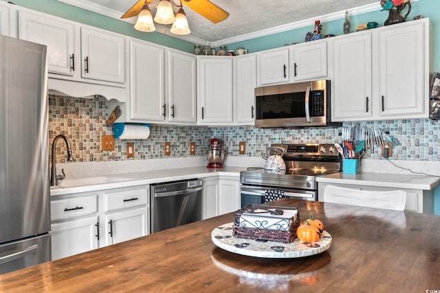 kitchen featuring ceiling fan, white cabinets, and stainless steel appliances