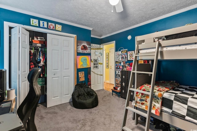 bedroom featuring ceiling fan, ornamental molding, a textured ceiling, a closet, and carpet floors