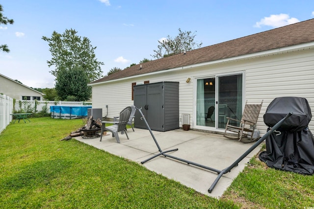 rear view of property with a patio, cooling unit, a yard, and a fenced in pool