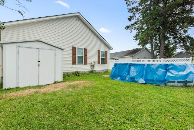 view of yard with a storage shed and a pool