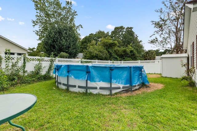 view of swimming pool with a storage unit and a yard