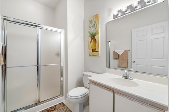 bathroom featuring tile patterned flooring, vanity, toilet, and a shower with shower door