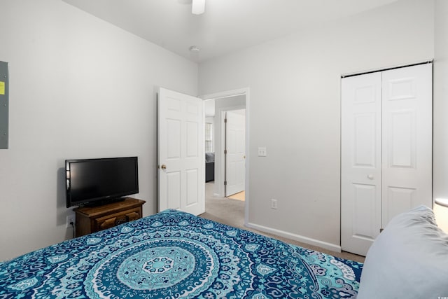 bedroom featuring ceiling fan, light colored carpet, and a closet