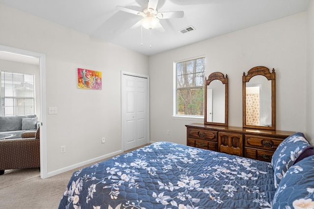 bedroom featuring light carpet, ceiling fan, and a closet