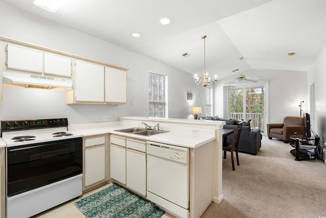 kitchen featuring white appliances, lofted ceiling, light carpet, and kitchen peninsula