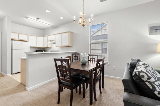 dining room featuring light carpet and a chandelier