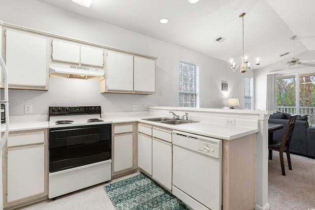 kitchen with vaulted ceiling, white appliances, kitchen peninsula, sink, and light colored carpet