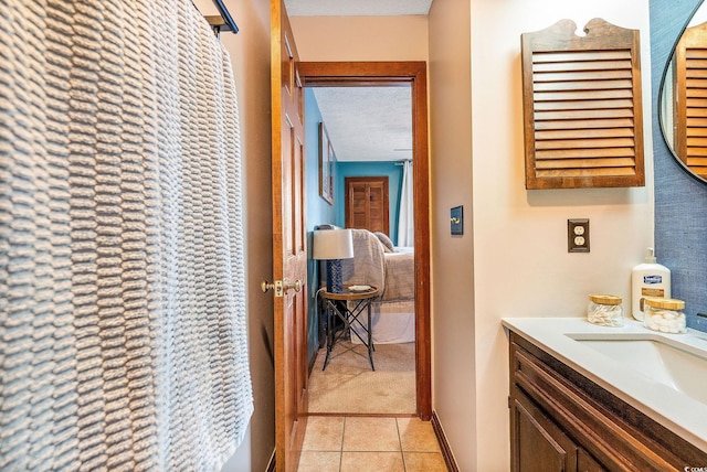 bathroom with tile patterned flooring, a textured ceiling, and vanity