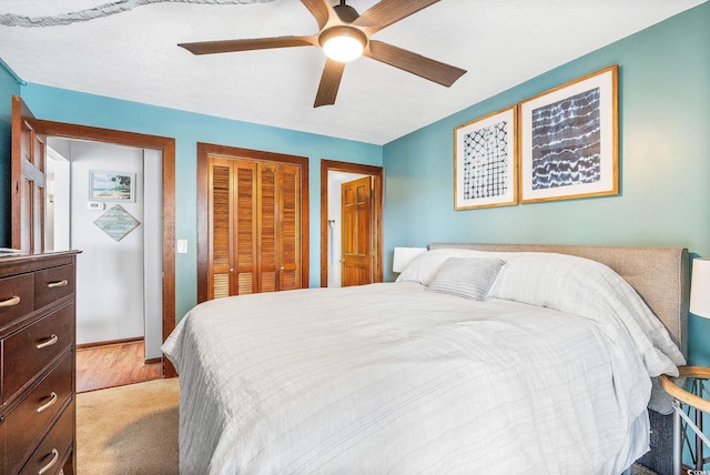 bedroom featuring carpet floors, a textured ceiling, ceiling fan, and a closet