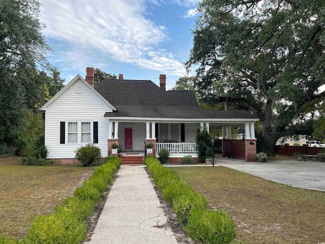 view of front of house with a porch and a front yard