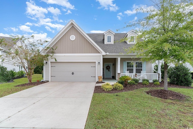 view of front of property featuring a garage, a porch, and a front lawn