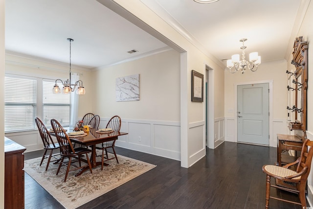 dining room featuring wainscoting, an inviting chandelier, dark wood-type flooring, and crown molding