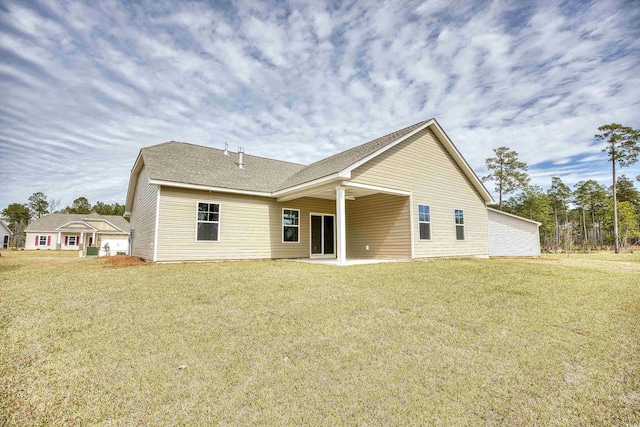 rear view of property featuring a yard and a patio area