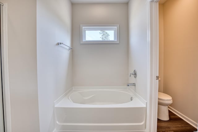 bathroom featuring a bath, wood-type flooring, and toilet