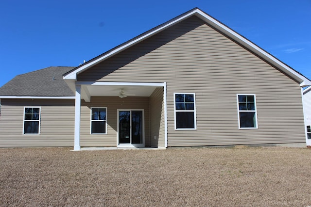 rear view of house with a yard and ceiling fan