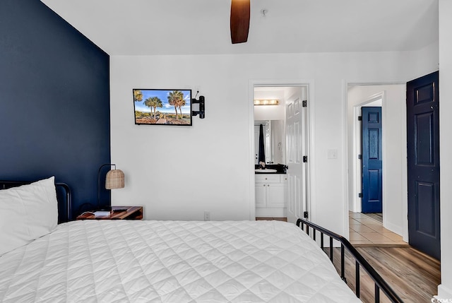 bedroom with connected bathroom, light hardwood / wood-style floors, and ceiling fan