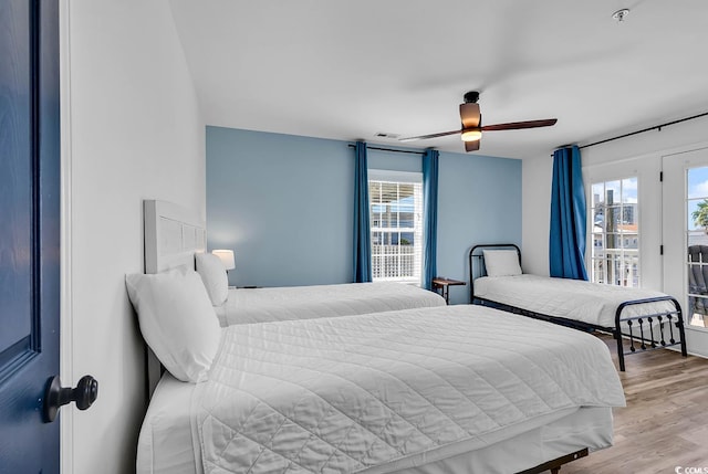 bedroom with light hardwood / wood-style floors, access to exterior, and ceiling fan